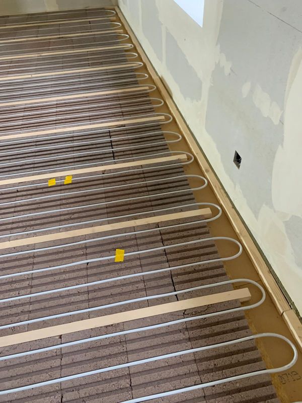 Heizrohre in Nutplatten entlang der Wand